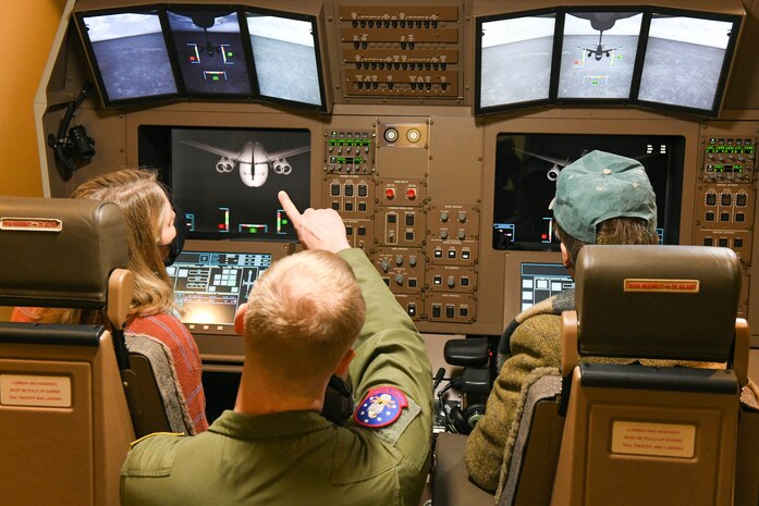 U.S. Air Force Master Sgt. Jon Lauterbach, 97th Training Squadron boom operator evaluator, shows Lt. Gen. (Ret.) Michelle Johnson and her husband, John Hargreaves, BOT a 3-D simulator on Altus Air Force Base, Jan. 7, 2022. The 3-D simulator helps KC-46 Pegasus boom operators train before taking their skills into a combat setting. (U.S. Air Force photo by Airman 1st Class Trenton Jancze)