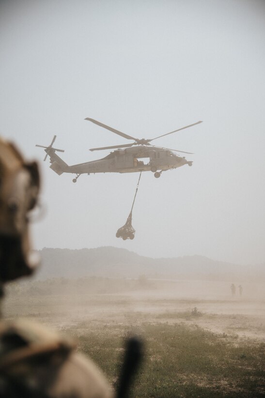 A U.S. Navy MH-60S Seahawk carries cargo away during sling-load training at a large-scale exercise in Logan, W.Va.., July 20, 2021. The training took place during a week-long exercise named Sentry Storm 2021 that featured multiple units from the Air and Army National Guard, U.S. Air Force, Air Force Reserve, U.S. Navy and Civil Air Patrol. (U.S. Air National Guard photo by Staff Sgt. Vincent Santos)