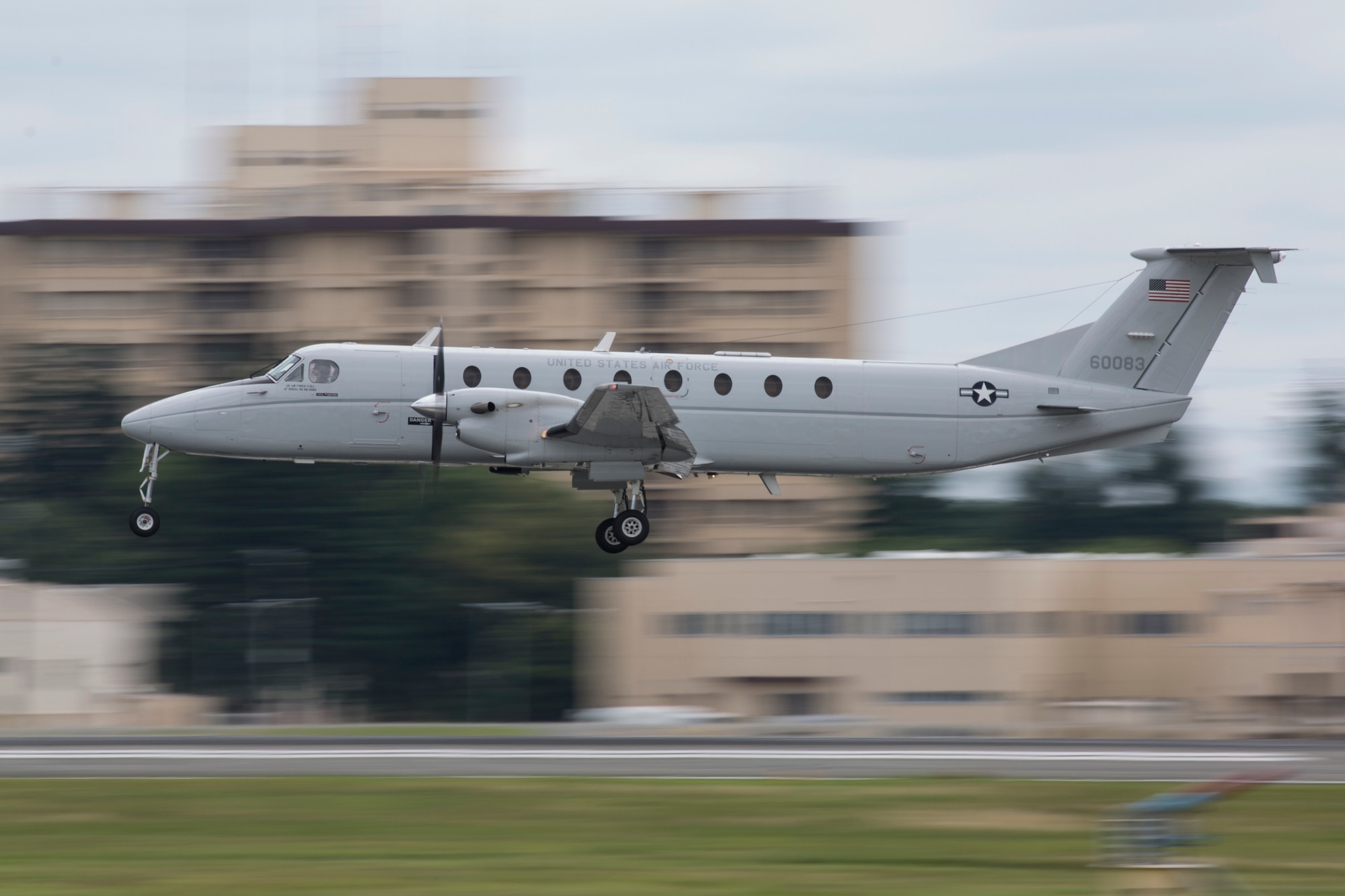 A small prop plane takes off from a military runway.