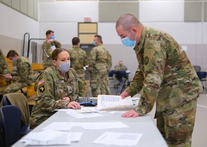Human resource specialist Sgt. Niki McCurdy from the 821 Troop Command Battalion, Oregon Army National Guard, assigns Soldiers to hospitals at the Anderson Readiness Center in Salem, Oregon, Jan. 12, 2022. By the end of January, more than 1,200 Citizen-Soldiers and Citizen-Airmen will be serving at 40 hospitals in the state facing a surge of COVID-19 cases.
