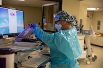 MANCHESTER, N.H. – U.S. Air Force Maj. Laura Ivy-Glines, the officer-in-charge of the medical augmentation team deployed to Manchester, New Hampshire, gathers medical supplies as part of the COVID response operations at Elliot Hospital, Jan. 10, 2022.