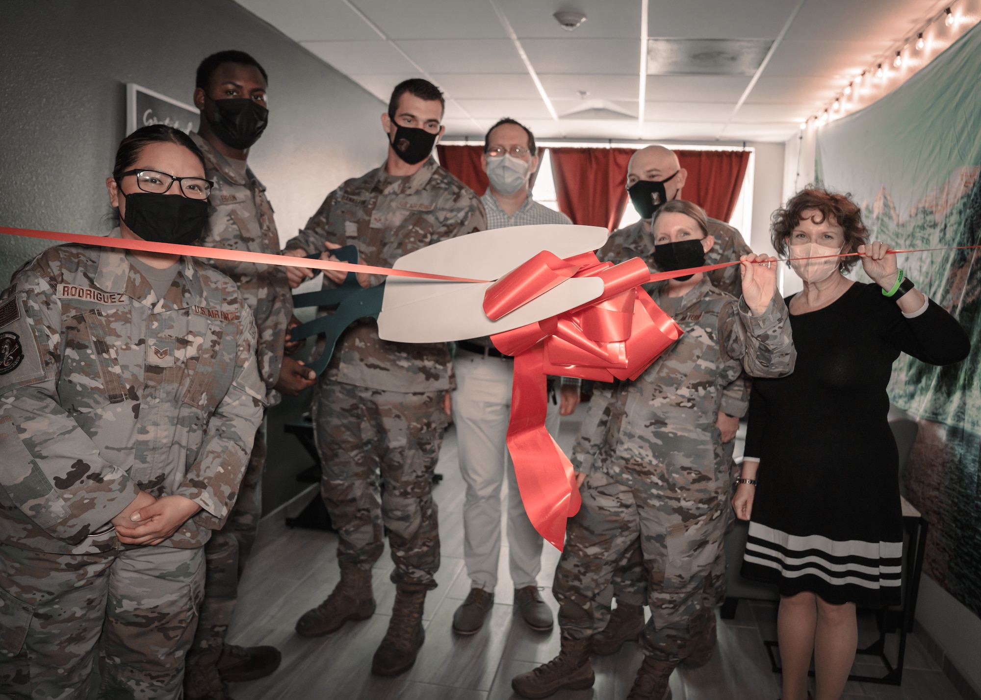 U.S. Air Force Senior Airman Joshua Bankston, 6th Maintenance Squadron aerospace propulsion technician, cuts a ribbon during the unveiling of the rest and relaxation (R&R) room on MacDill Air Force Base, Florida, Jan. 7, 2022.