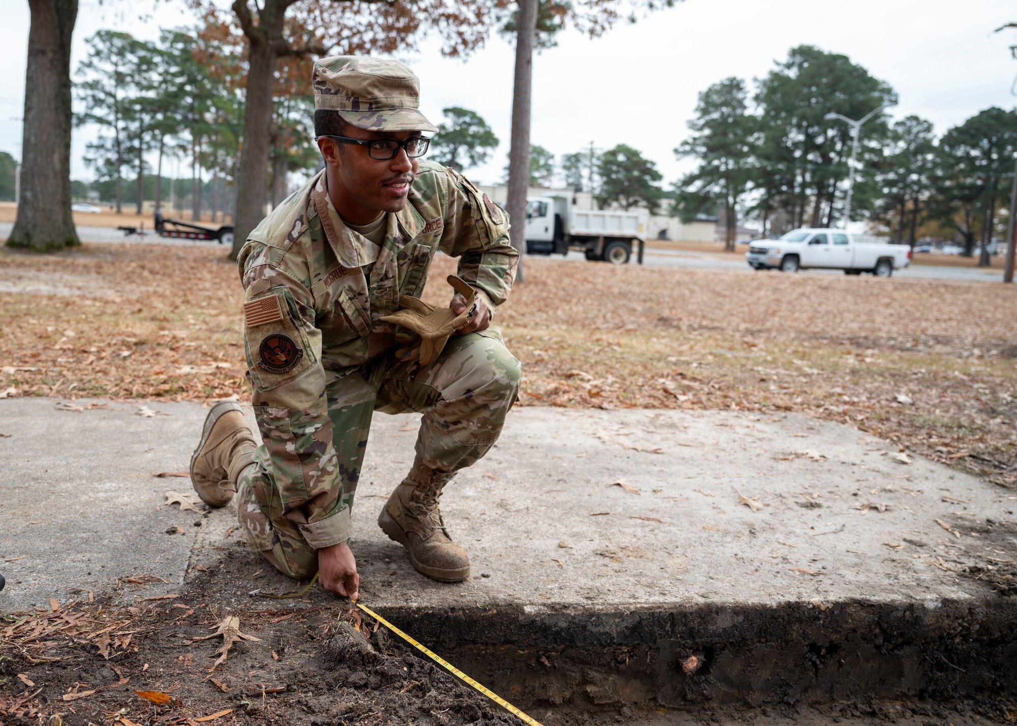 Airman 1st Class Dametric McGrue, 4th Civil Engineer Squadron maintenance and pavement technician, measures the length for a new sidewalk at Seymour Johnson Air Force Base, North Carolina, Dec. 9, 2021.