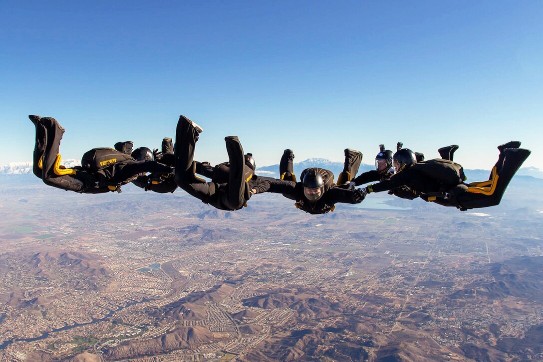 A parachute team performs a six-way jump over a city.