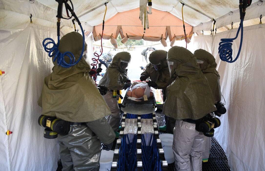 Keesler medics prepare to wash a simulated patient during a decontamination training course behind the Keesler Medical Center at Keesler Air Force Base, Mississippi, Jan. 6, 2022. The course provided the tools and skills necessary to maintain an effective level of decontamination operational ability in the event of a chemical, biological, radiological or nuclear incident. (U.S. Air Force photo by Kemberly Groue)