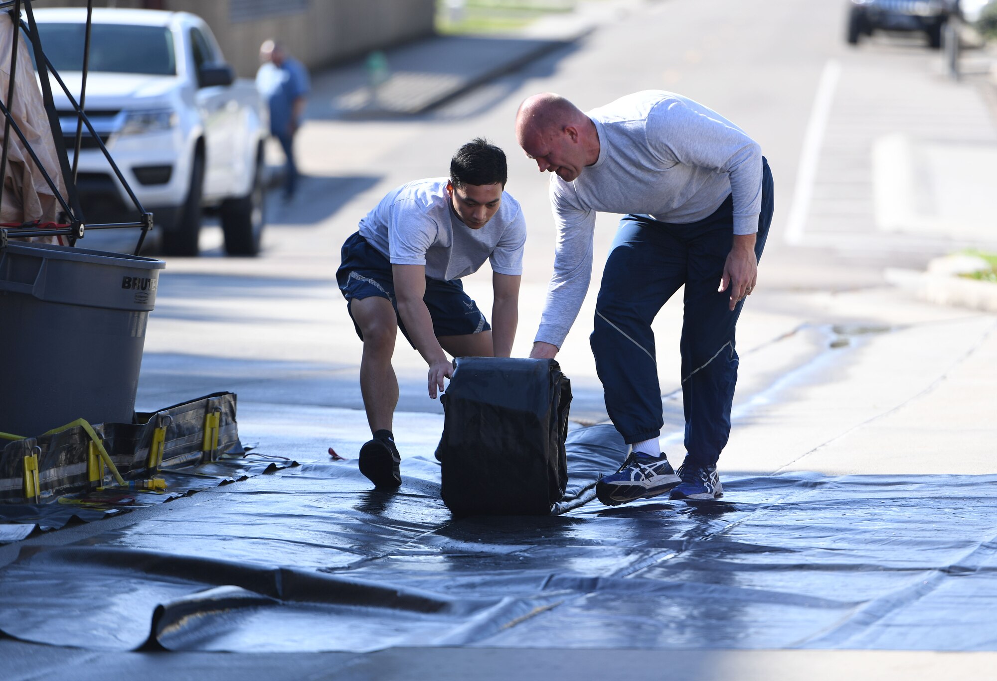 U.S. Air Force Airman 1st Class Lars Bernard, 81st Dental Squadron dental lab technician, and Maj. Craig England, 81st Operational Medical Readiness Squadron optometry flight commander, assemble a decontamination site during a decontamination training course behind the Keesler Medical Center at Keesler Air Force Base, Mississippi, Jan. 6, 2022. The course provided Keesler medics with the tools and skills necessary to maintain an effective level of decontamination operational ability in the event of a chemical, biological, radiological or nuclear incident. (U.S. Air Force photo by Kemberly Groue)