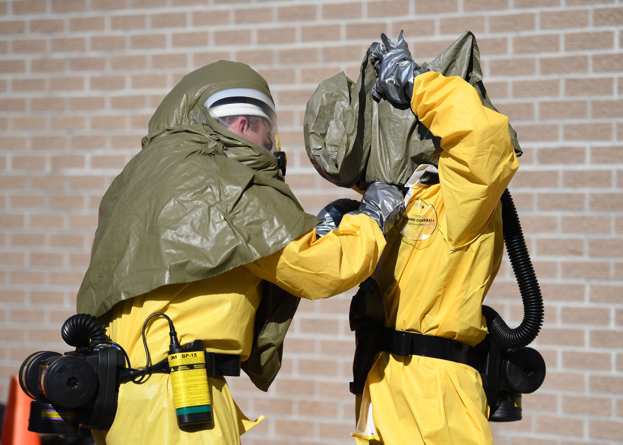 U.S. Air Force Capts. Quentin Hudson and Dixie Mobley, 1st Special Operations Medical Group dentists, Hurlburt Field, Florida, put on decontamination suits during a decontamination training course behind the Keesler Medical Center at Keesler Air Force Base, Mississippi, Jan. 6, 2022. Airmen from Keesler AFB, Hurlburt Field and Columbus Air Force Base attended the course, which provided the tools and skills necessary to maintain an effective level of decontamination operational ability in the event of a chemical, biological, radiological or nuclear incident. (U.S. Air Force photo by Kemberly Groue)