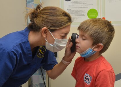 JACKSONVILLE, Fla. (Nov. 30, 2021) - Lt. Cmdr. Kaitlyn Schiavone, a dermatologist at Naval Hospital Jacksonville, conducts an exam with a 6-year-old.  Schiavone holds a doctor of osteopathic medicine degree from Lake Erie College of Osteopathic Medicine.  A native of Sarasota, Florida, she says, "Skin checks are a type of preventive care.  They can be helpful indicators of internal health and can detect lesions of concern early, before complications develop."  (U.S. Navy photo by Deidre Smith, Naval Hospital Jacksonville/Released).