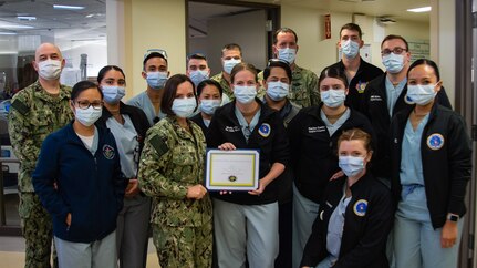 SAN DIEGO (Jan. 11, 2022) Lt. Molly Clark, a Sailor assigned to Navy Medicine Readiness and Training Command (NMRTC) San Diego’s Directorate for Nursing Services (center right) receives an award from Capt. Kim Davis, NMRTC San Diego’s commanding officer (center left), for Junior Officer of the Year FY21 Jan. 11.
