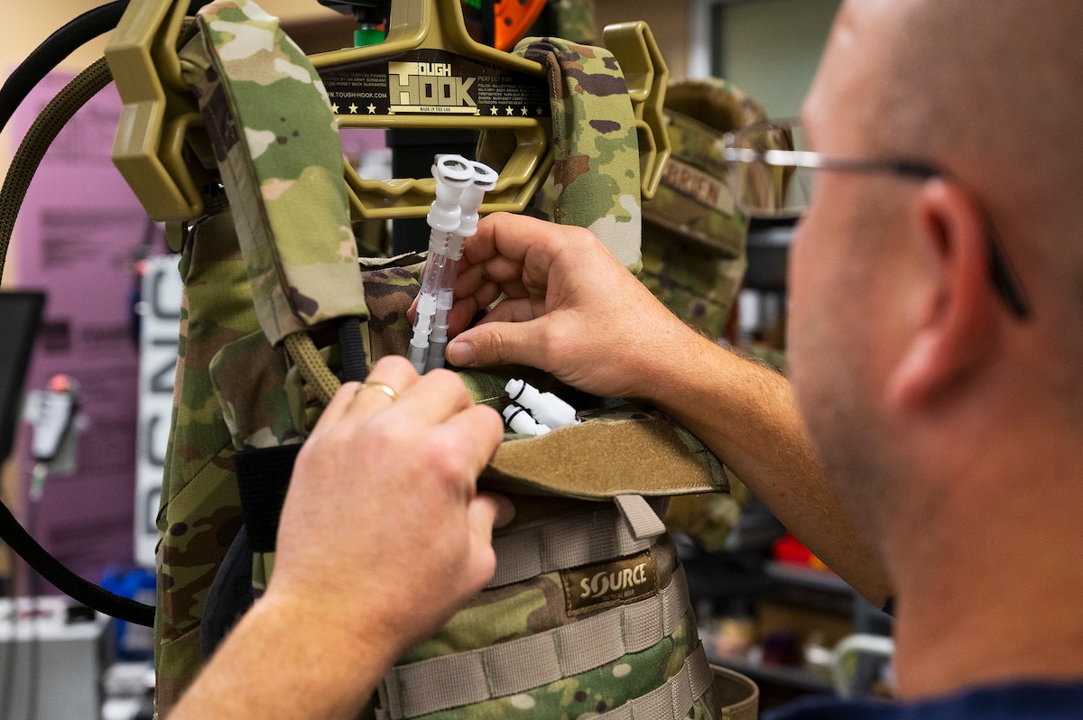 Matthew Sunday, an engineer with the Wright Brothers Institute’s Rapid Innovation Program, works on the liquid-cooled plate carrier prototype Dec. 1, 2021, at his lab in Riverside, Ohio. The system uses a small pump to circulate water and cool service members wearing body armor. (U.S. Air Force photo by R.J. Oriez)