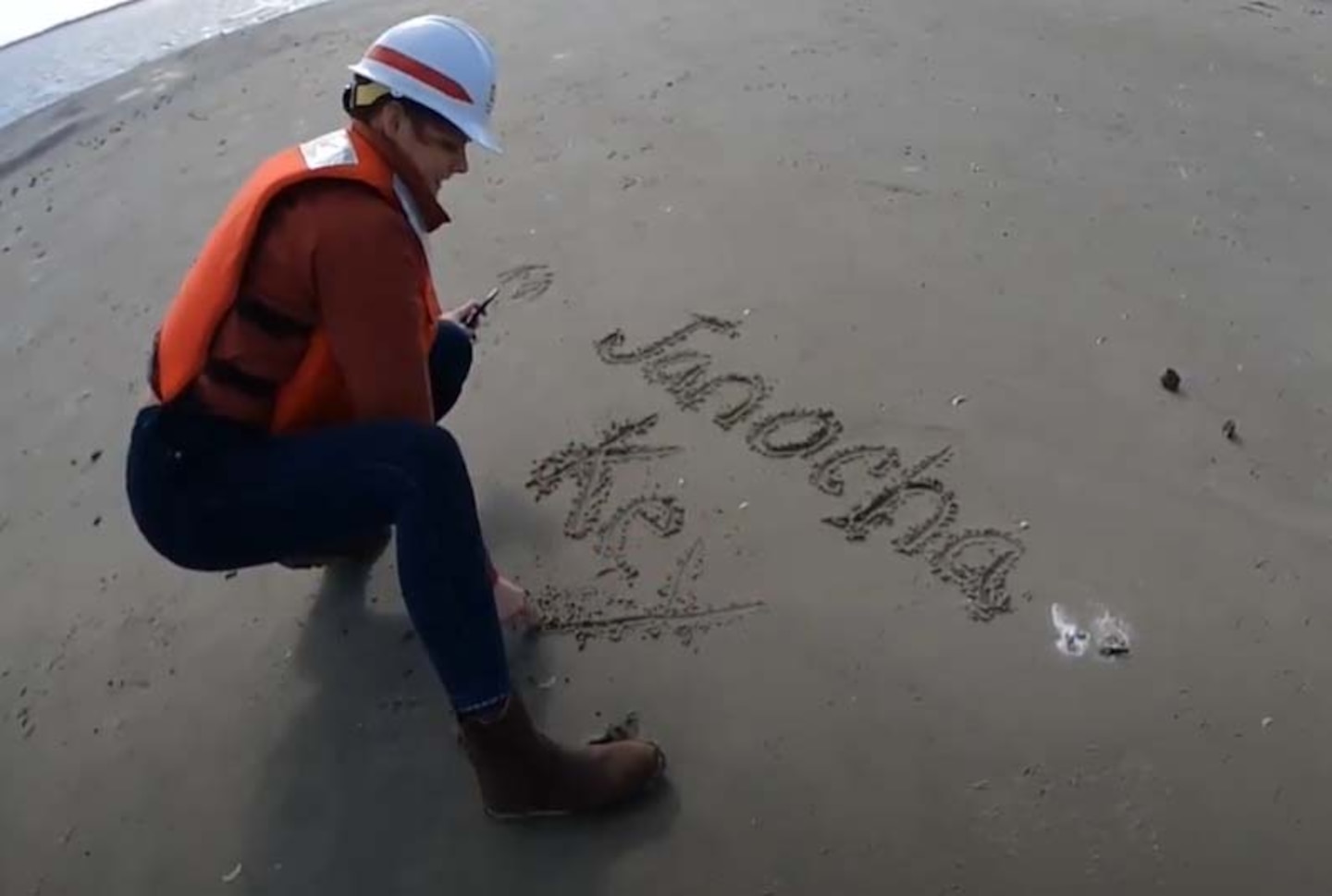 Erica Janocha, Savannah District biologist, writes “Janocha Key” in the sand on the new Altamaha bird island.