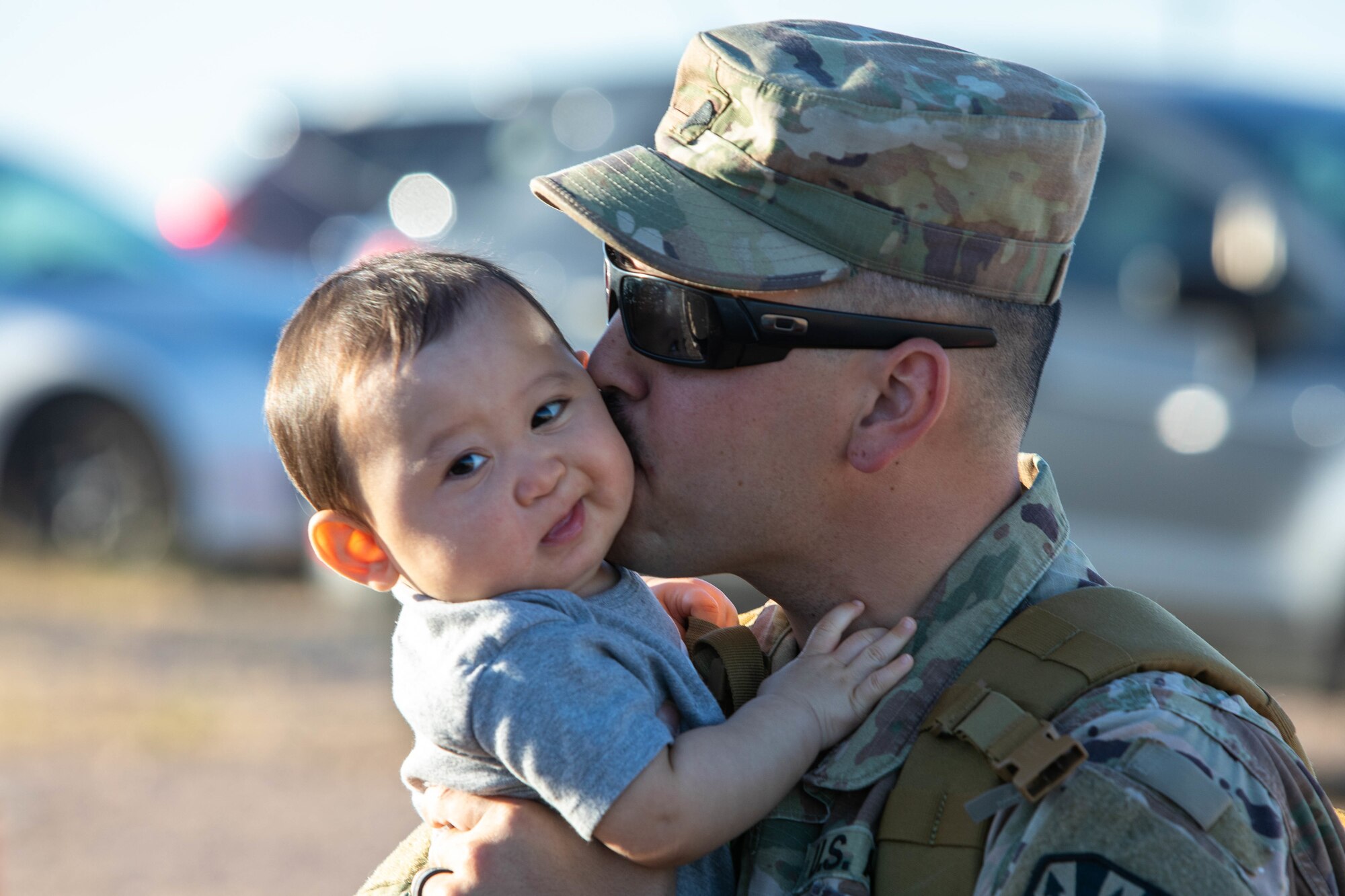 A service member kisses infant son