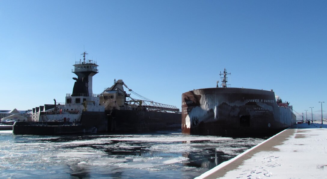 It's a tight fit for two boats in the Soo Locks approach canal at the same time in Sault Ste. Marie, Mich. Corps of Engineers policy requires that boats be secured to the pier while the departing vessel passes. Look closely and you will see deckhands standing by to cast off the Barker's lines and lead the vessel into the lock once the tug/barge has passed.