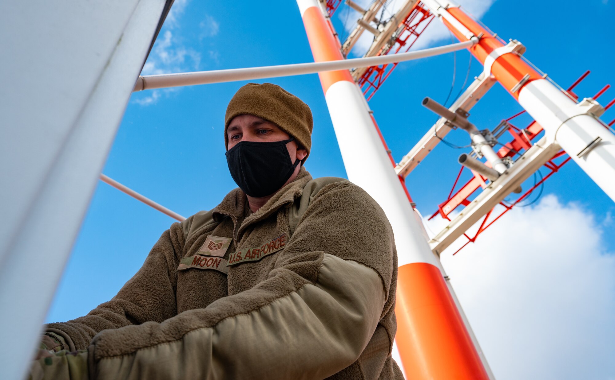 RAWS technicians inspect wire connections on glide slope antenna tower.