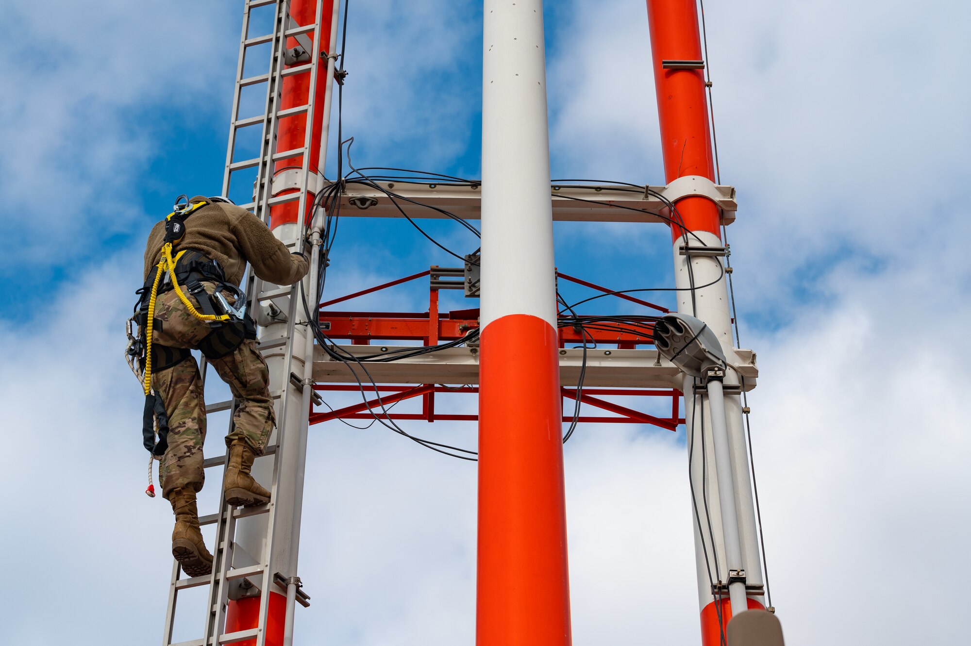 RAWS technicians inspect wire connections on glide slope antenna tower.