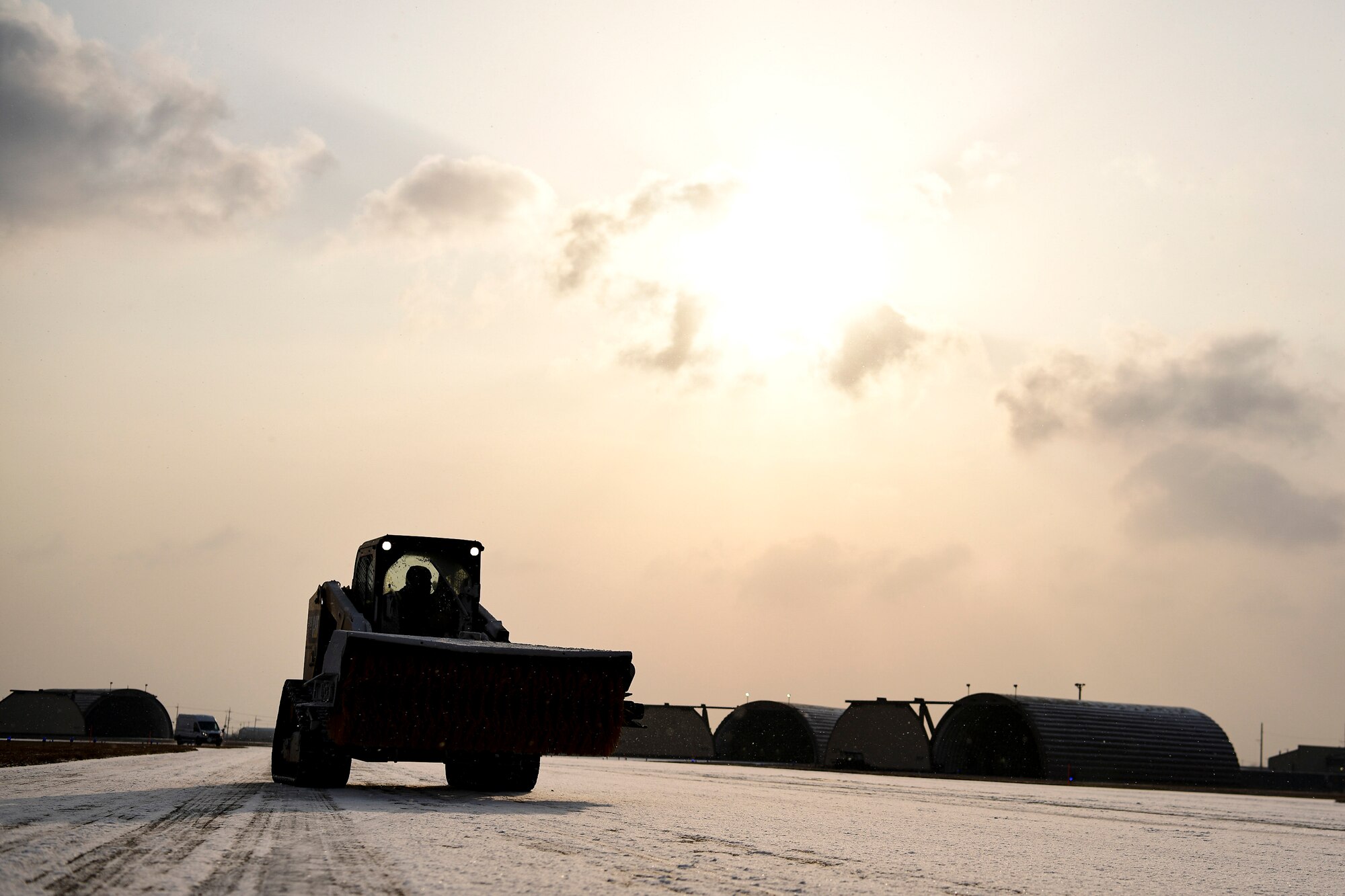 An Airman removes snow on the flightline.