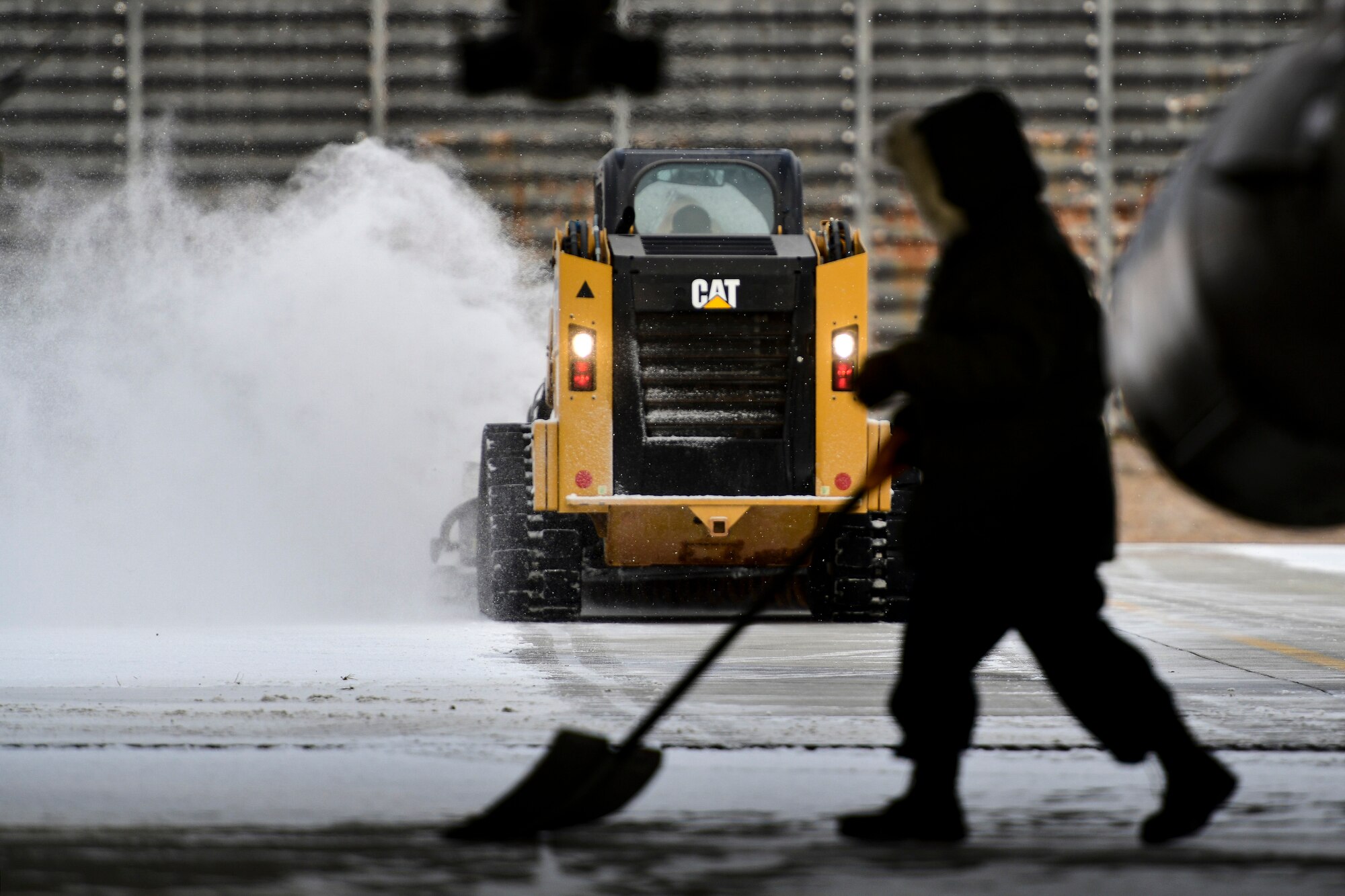 An Airman removes snow on the flightline.