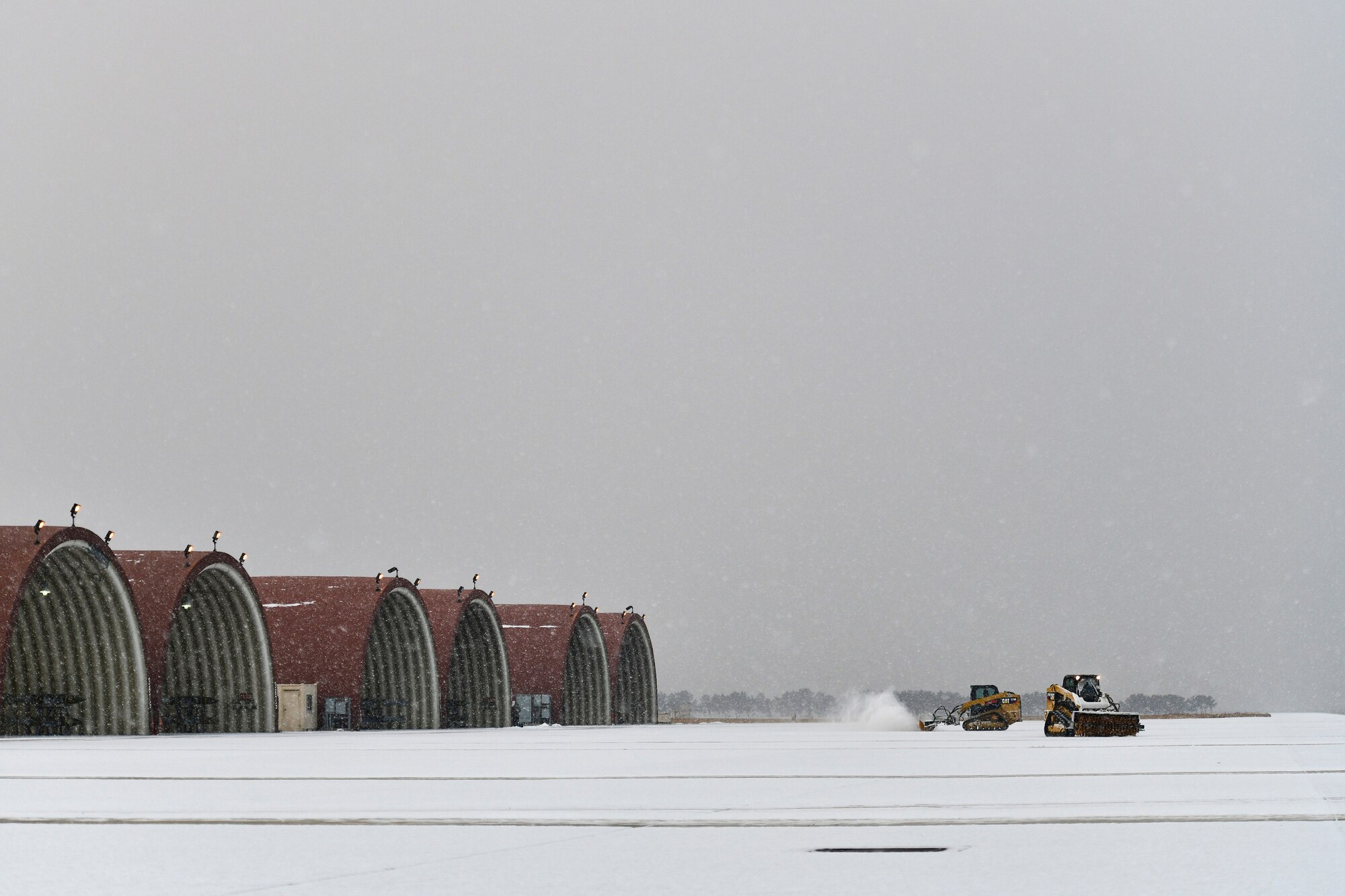 Airmen removes snow on the flightline.