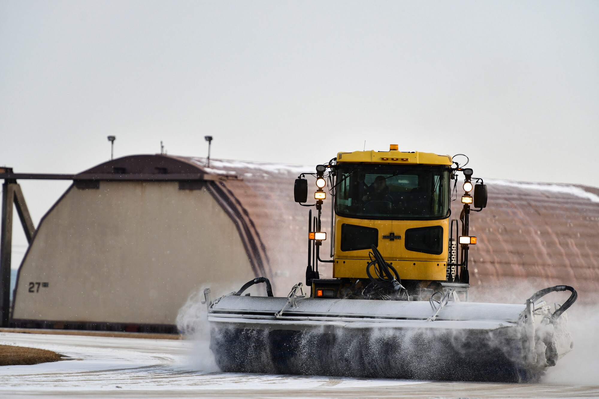 An Airman removes snow on the flightline.