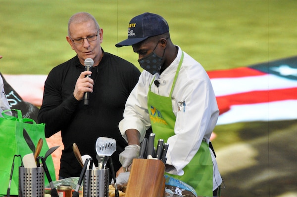 Food Network personality Robert Irvine discusses ingredients with Culinary Specialist 2nd Class Louis Lubin during the annual Army/Navy Cook-off at the Pennsylvania Farm Show in Harrisburg, Penn.
