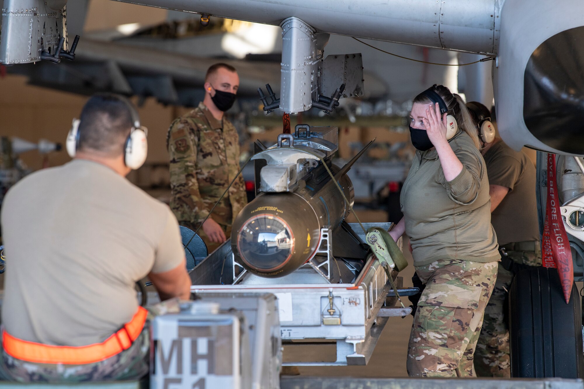 Photo of Airmen loading munitions to aircraft