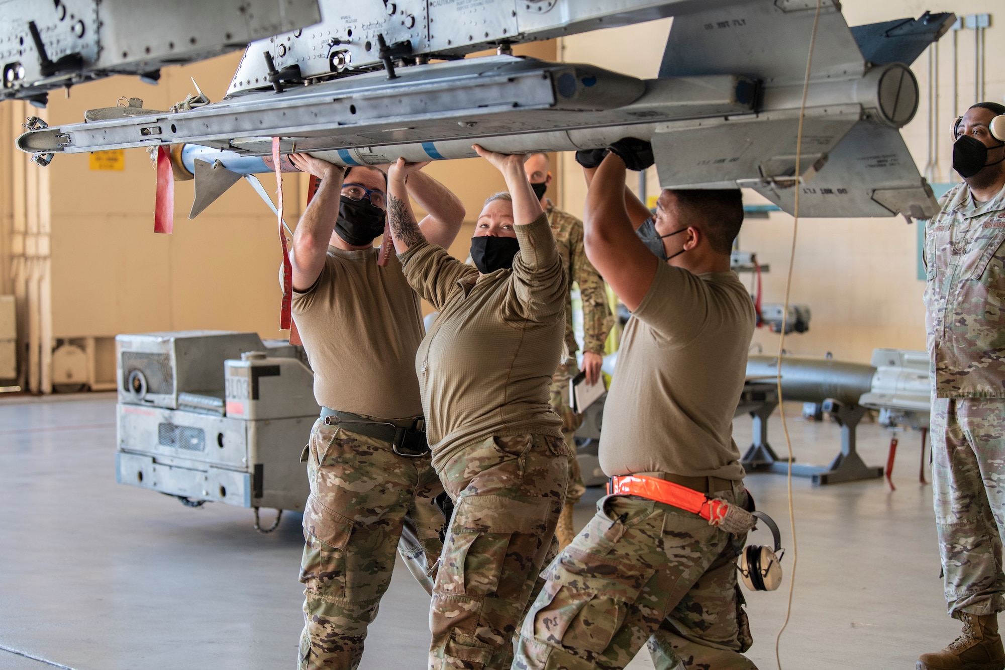 Photo of Airmen loading munitions to aircraft