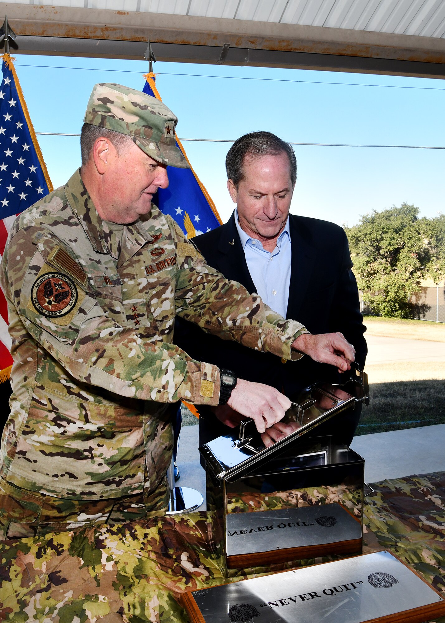 U.S. Air Force Lt. Gen. Marshall B. Webb (left), Commander, Air Education and Training Command, Joint Base San Antonio-Randolph, Texas, and former U.S. Air Force Chief of Staff Gen. David Goldfein (ret.) (right) seal the SWTW aquatics training center heritage capsule while standing in front of the future site of the Special Warfare Training Wing aquatics training facility