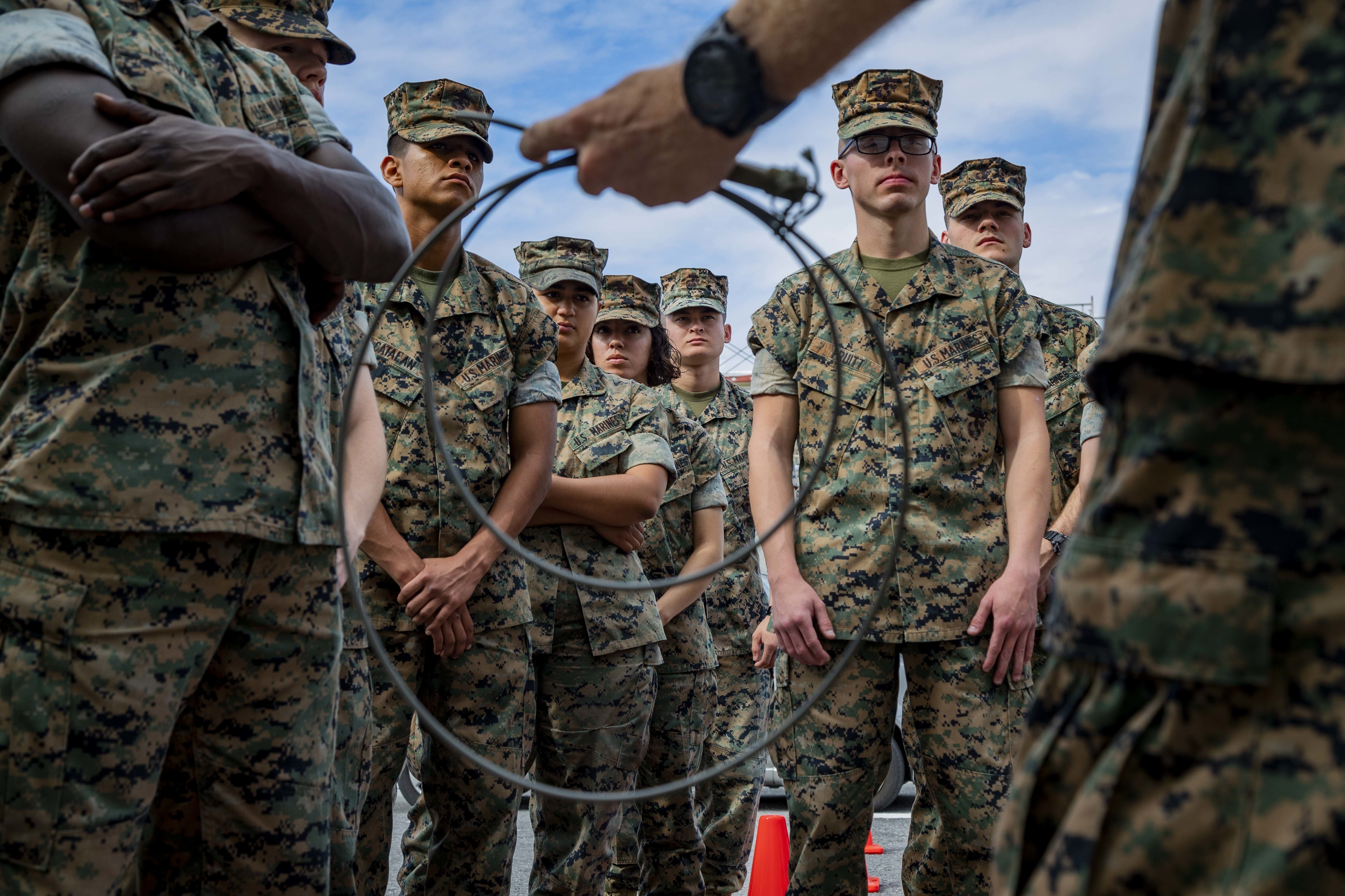 Marines standing facing an instructor in uniform.