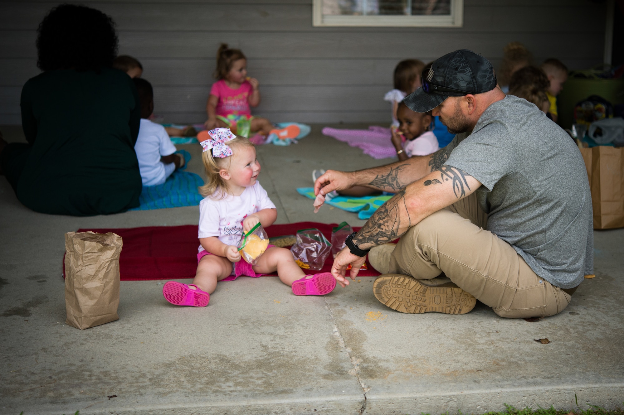 man sitting on the floor eating lunch with his daughter