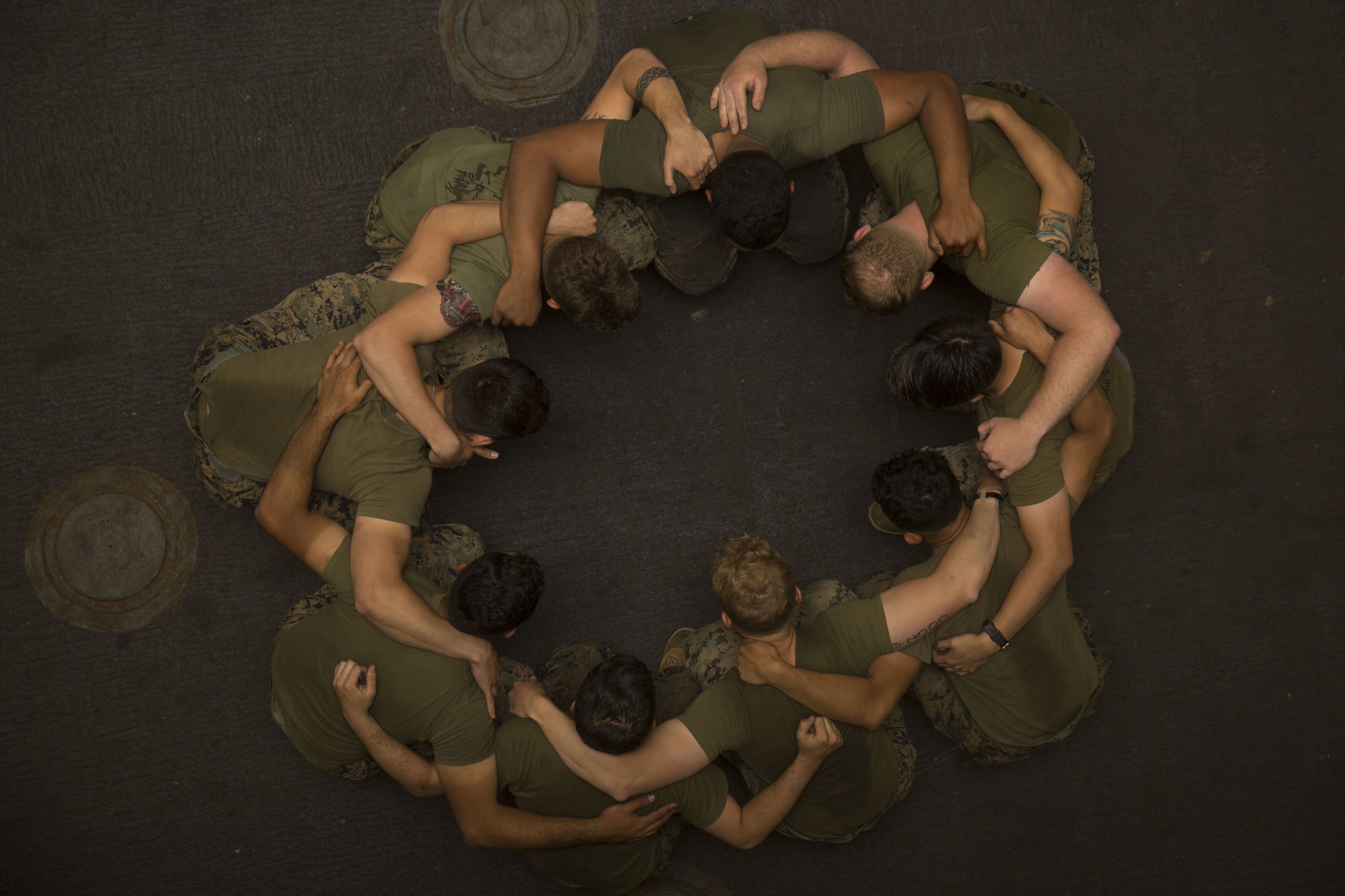 Top view of Marines with their arms around each other in a circle.