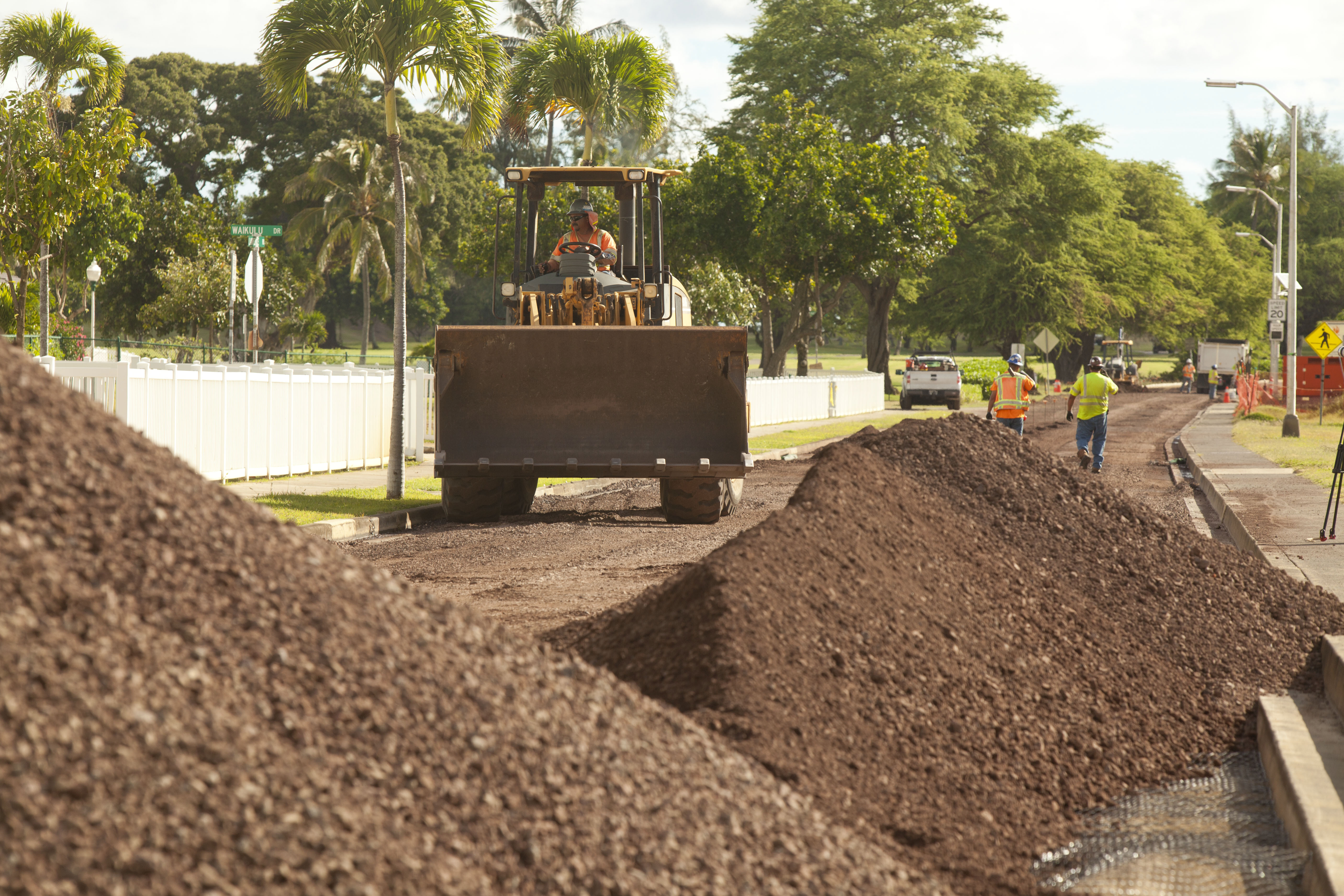 A construction vehicle driving through mounds of dirt.