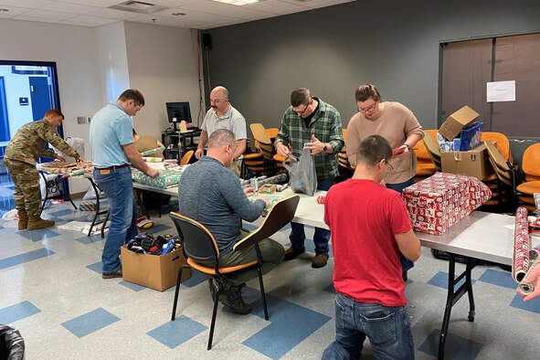 Airmen from the 167th Operations Group wrap Christmas gifts for local children as part of the Ops Adopts program at the 167th Airlift Wing, Shepherd Field, Martinsburg, West Virginia, Dec. 16, 2022. The program provided gifts for children of 35 families this year.