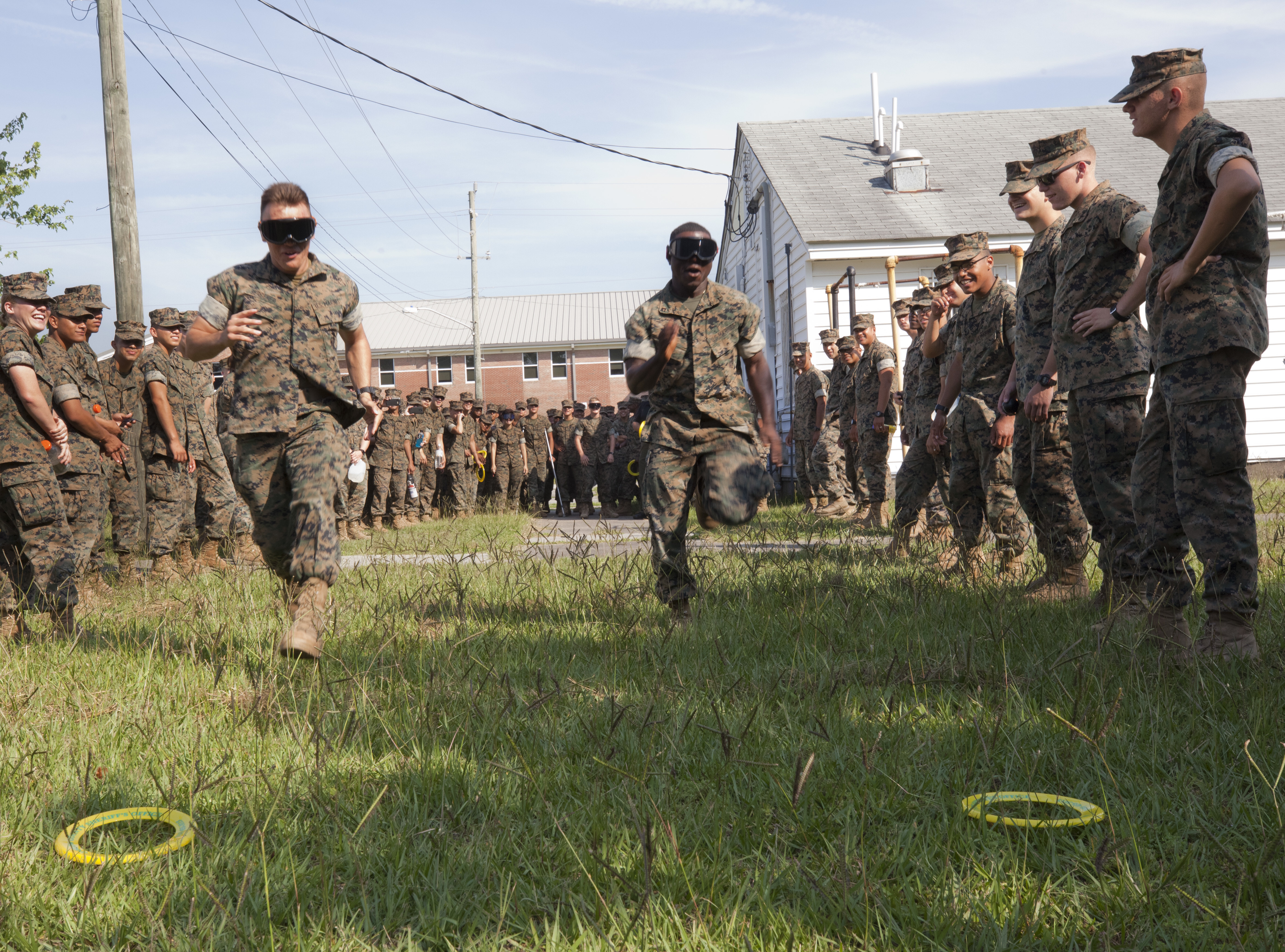 Two Marines competing in a fun race in the grass.