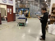A worker at the U.S. Army Medical Materiel Center-Korea operates a new robotics carrier system to transport customer orders in the USAMMC-K warehouse. The system has increased efficiency and reduced manpower needs for processing orders for medical supply. (U.S. Army by Master Sgt. Rizmel Paguio)
