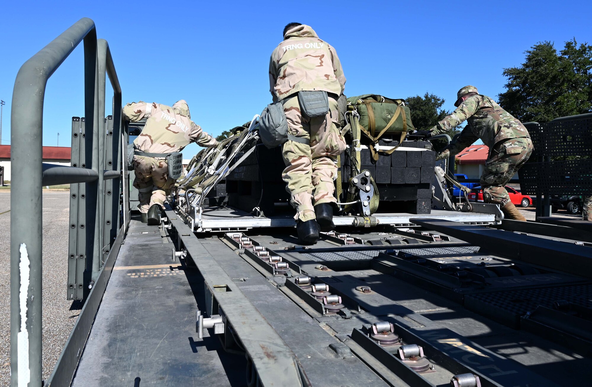 Airmen pushing cargo onto a lift