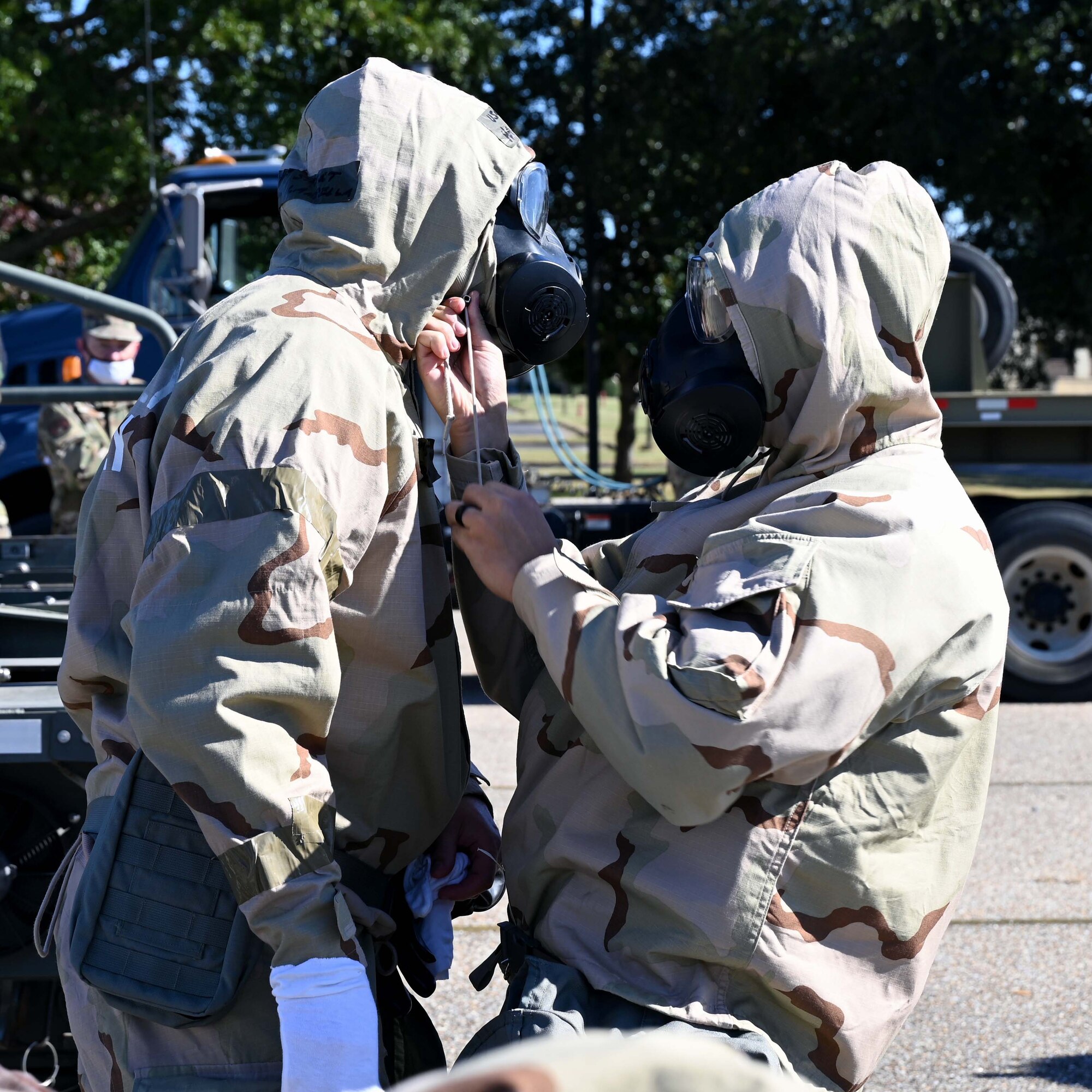 two airmen helping put gear on