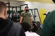 Staff Sgt. Neil French, a U.S. Army Warrior Fitness Team athlete, demonstrates the deadlift exercise for students at Miami Jackson Senior High School during a school visit in support of Army Recruiting and Outreach in Miami, Florida on Jan. 12, 2022.