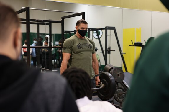 man lifting weights in front of crowd.