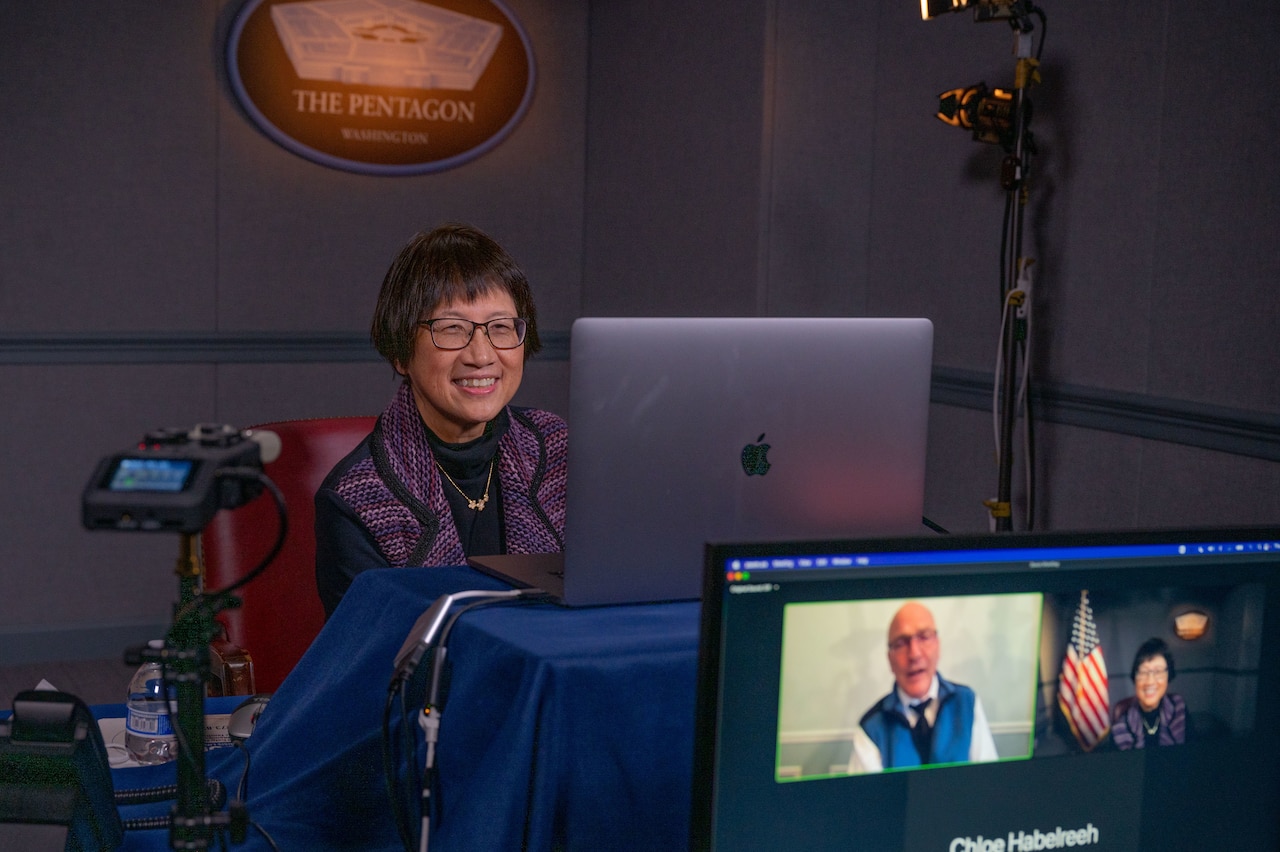 Woman speaks virtually to the media.