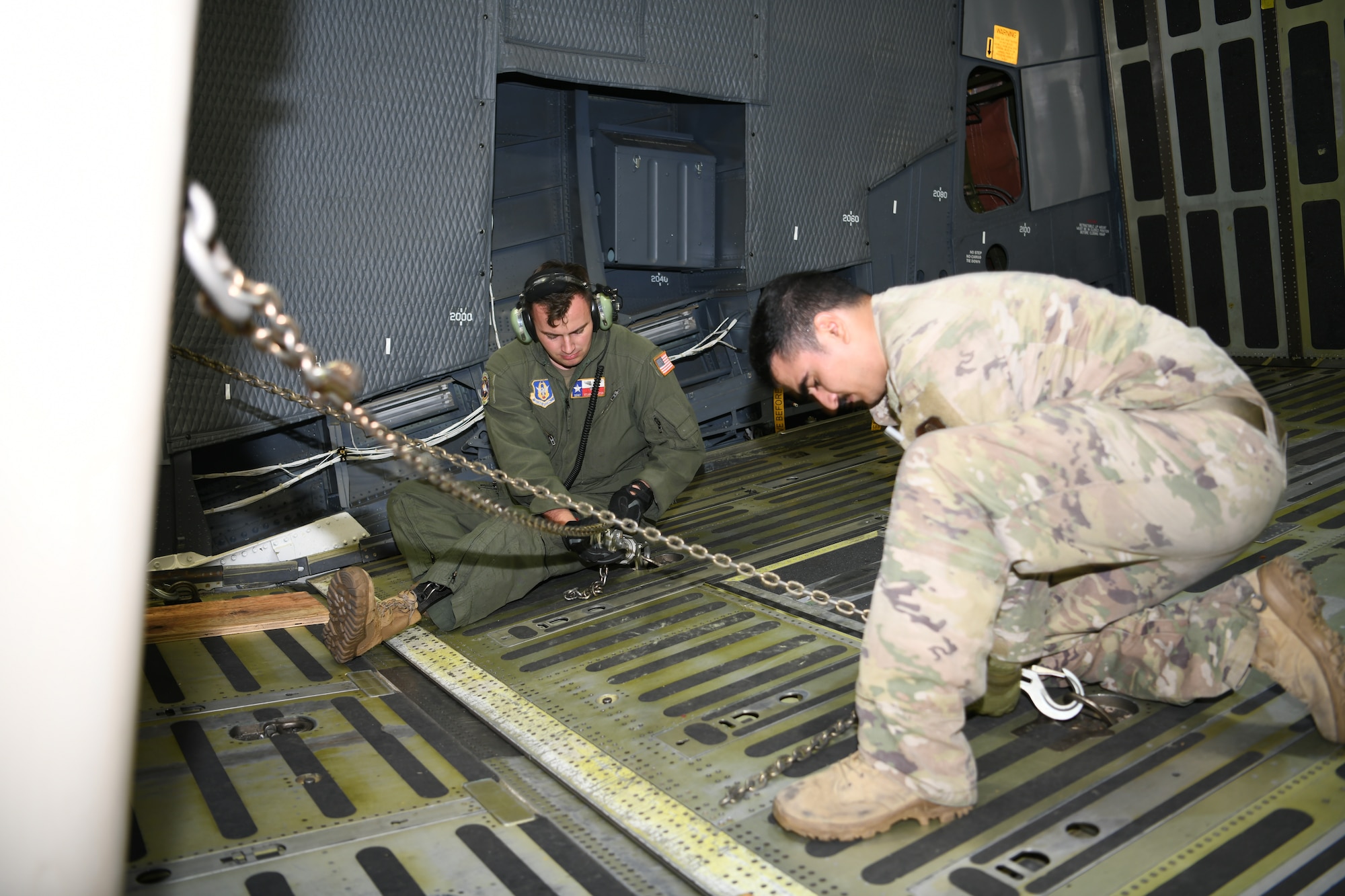 Staff Sgt. Stuart Martin, 68th Airlift Squadron loadmaster (left), secures cargo to the floor of a C-5M Super Galaxy aircraft Sept. 13, 2021 at Joint Base San Antonio-Lackland, Texas. Martin was working to regain his loadmaster certifications following a motorcycle accident where he lost a leg. (U.S. Air Force photo by Master Sgt. Kristian Carter)