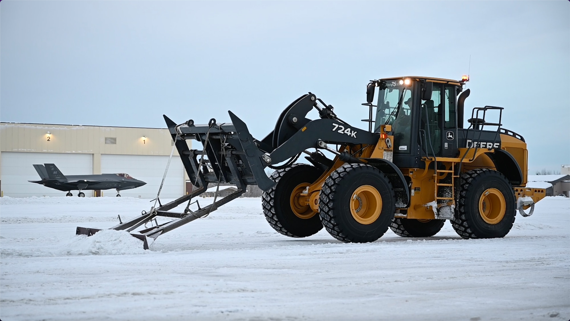 A 354th Civil Engineering Squadron pavements and construction equipment operator clears ice from the flight line at Eielson Air Force Base, Alaska, Jan. 13, 2022.