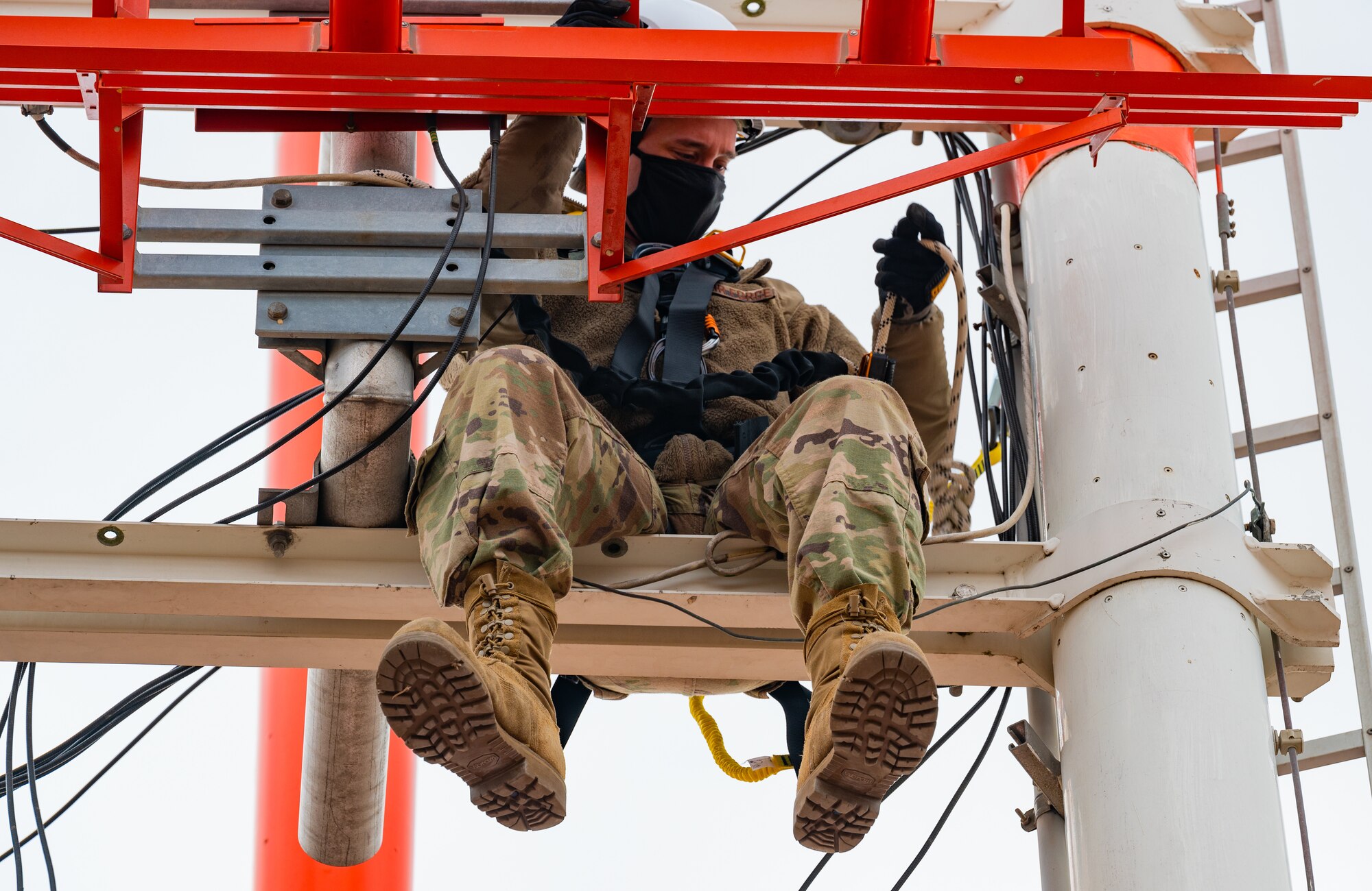 RAWS technicians inspect wire connections on glide slope antenna tower.