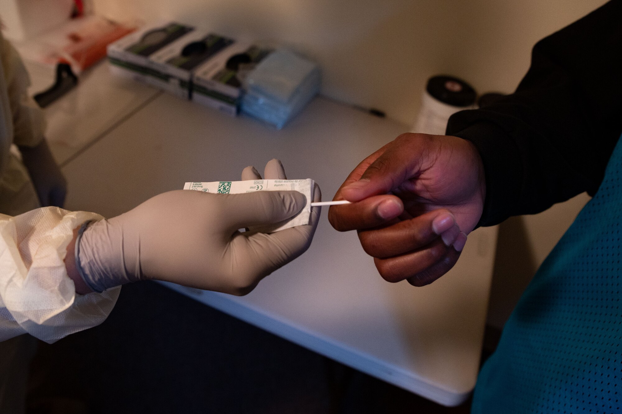 U.S. Air Force Staff. Sgt. Bradley Borytsky, 51st Operational Medical Readiness Squadron mental health technician, hands a COVID-19 antigen testing swab to Staff Sgt. Aaron Wynn, 51st Medical Support Squadron NCO in charge of the medical equipment office, to simulate proper procedures of how to administer an antigen test at Osan