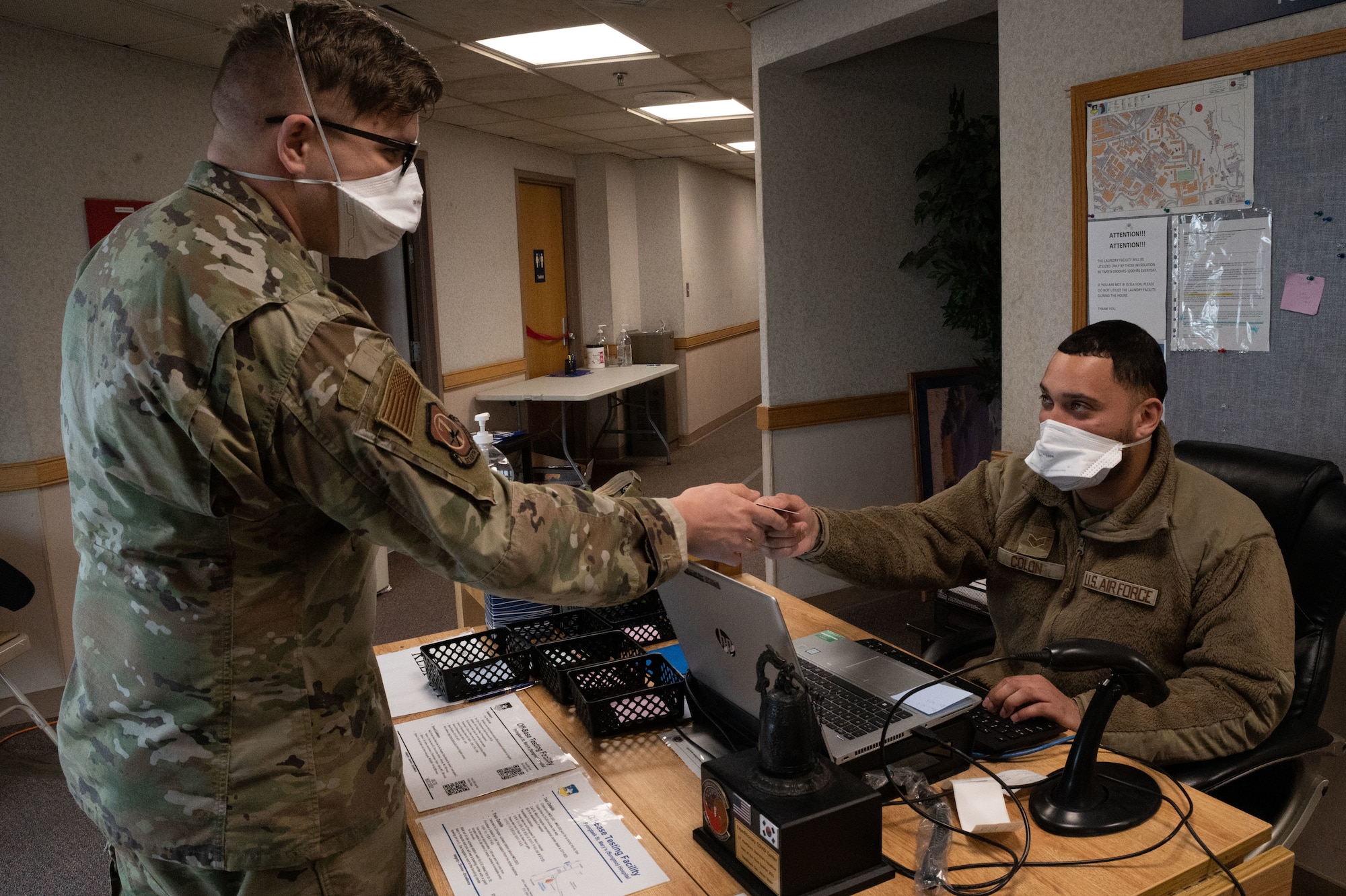 U.S. Air Force Staff. Sgt. Bradley Borytsky, 51st Operational Medical Readiness Squadron mental health technician, hands Senior Airman Alix Colon 51st Medical Support Squadron medical administrator, his common access card at Osan