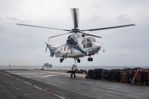 Cpl. Hunter Bienvenu, from Lebanon, N.H., front, and Cpl. Nicholas Beatty, from Sammamish, Wash., conduct vertical replenishment operations with an Aerospatiale SA 330 Puma, assigned to the dry cargo and ammunition ship USNS Alan Sheppard (T-AKE 3), aboard the amphibious assault ship USS Essex (LHD 2), Jan. 13.