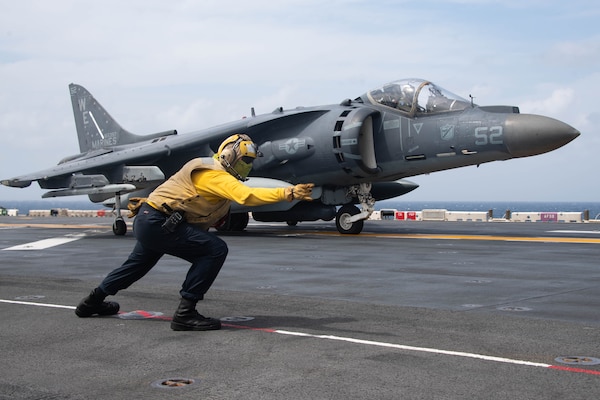 Aviation Boatswain’s Mate 3rd Class Alissa Sanchez, from Las Cruses, Calif., signals to an AV-8B Harrier attached to Marine Attack Squadron (VMA) 214, 11th Marine Expeditionary Unit (MEU), on the flight deck of the amphibious assault ship USS Essex (LHD 2), Jan. 14