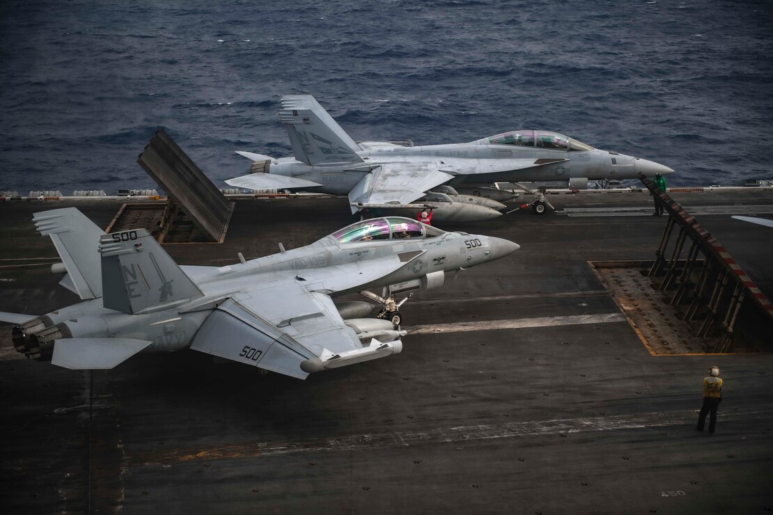 An F/A-18F Super Hornet, assigned to the “Bounty Hunters”  of Strike Fighter Squadron (VFA) 2 and an EA-18G Growler, assigned to the “Gauntlets” of the Electric Attack Squadron (VAQ) 136, prepare to launch off the flight deck Nimitz-class aircraft carrier USS Carl Vinson (CVN 70), Jan. 15, 2022.