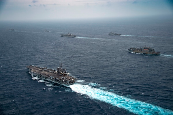 From left, Arleigh Burke-class guided-missile destroyer USS Michael Murphy (DDG 112), Henry J. Kaiser-class fleet replenishment oiler USNS John Ericsson (T-AO 194), Nimitz-class aircraft carrier USS Carl Vinson (CVN 70), Arleigh Burke-class guided-missile destroyer USS O’Kane (DDG 77), Wasp-class landing helicopter dock USS Essex (LHD 2), Harpers Ferry-class dock landing ship USS Pearl Harbor (LSD 52), and Lewis and Clark-class dry cargo ship USNS Alan Shephard (T-AKE 3) transit the South China Sea, Jan. 13, 2022. Carl Vinson Carrier Strike Group (VINCSG) and Essex Amphibious Ready Group (ESX ARG) are conducting joint expeditionary strike force operations in the South China Sea as part of continuing and routine interoperability training operations in the Indo-Pacific region.