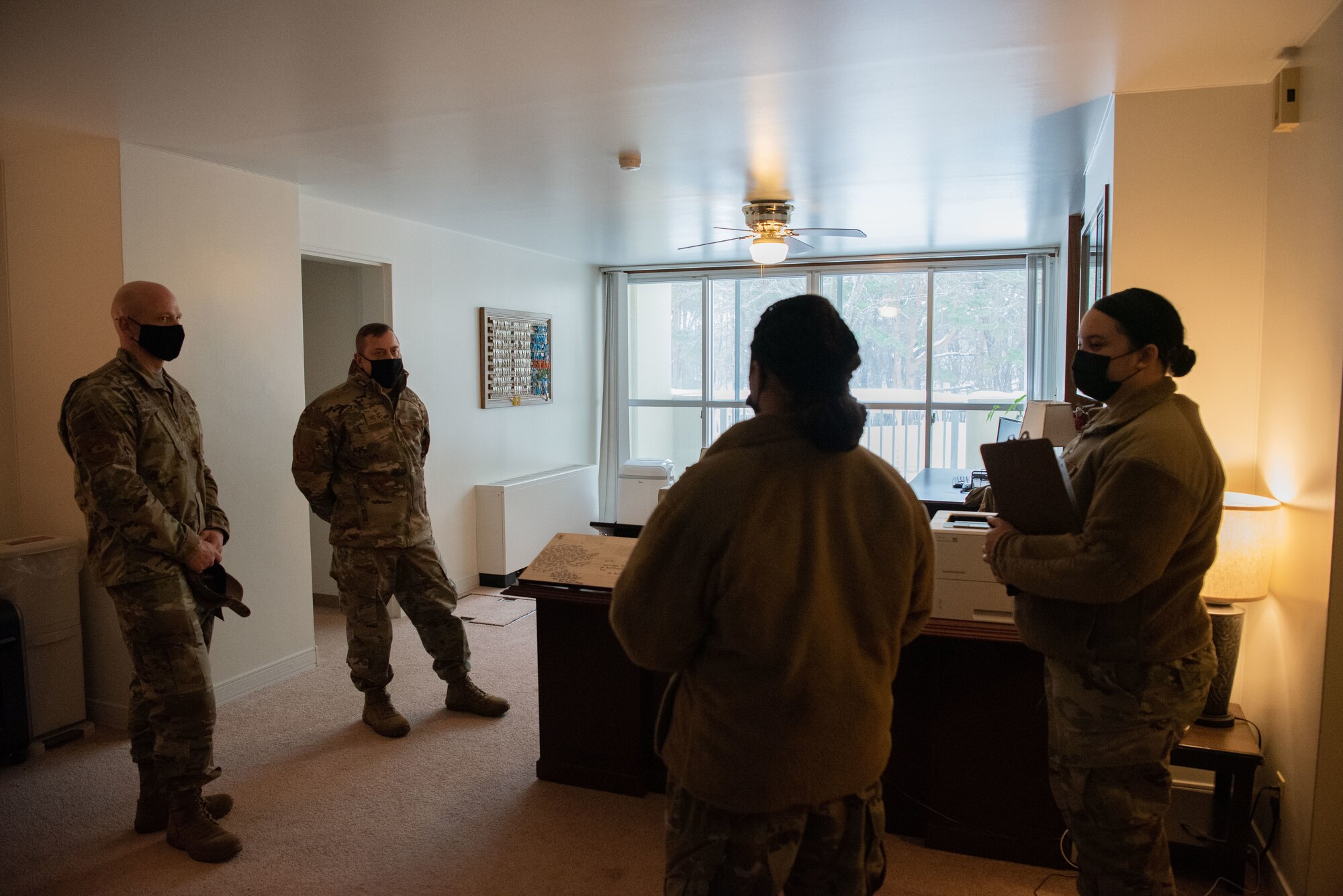 Members stand in a circle in an office in the contingency dorms.