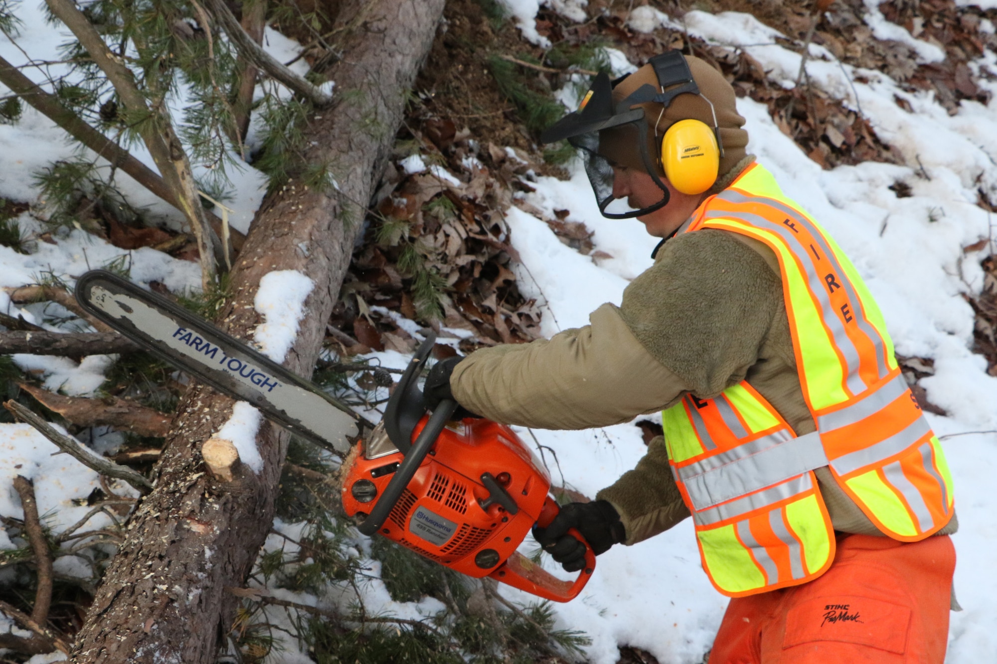 Virginia National Guard Airmen assigned to the Virginia Beach-based 203rd Rapid Engineer Deployable Heavy Operational Repair Squadron Engineers, 192nd Mission Support Group, 192nd Wing, use chainsaws to clear roads of fallen trees Jan. 7, 2022, in Stafford County, Virginia.